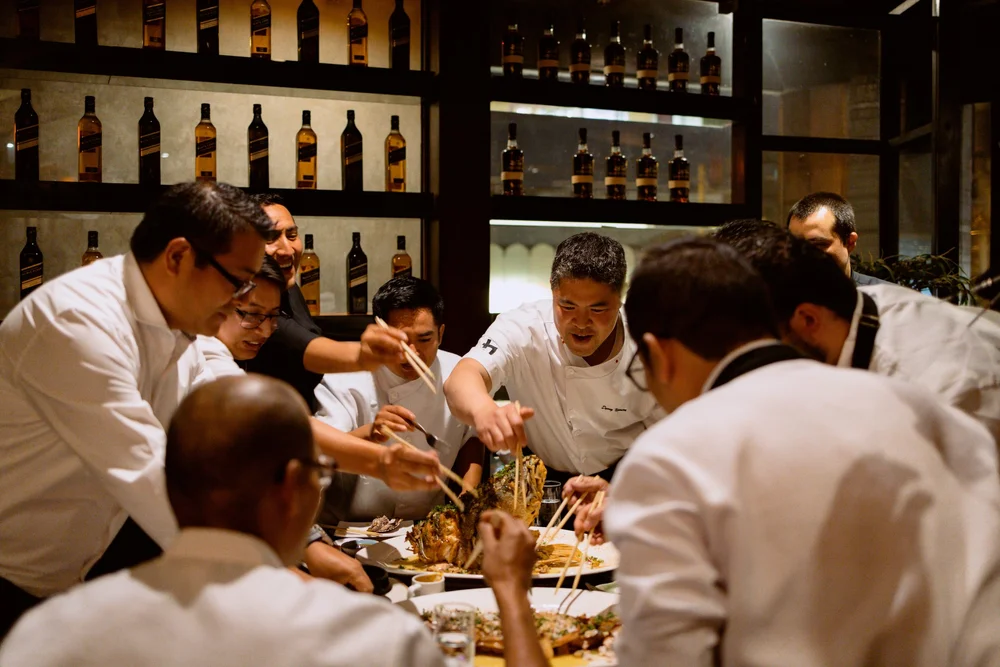 Chefs gather around a table in a scene from BUNKA